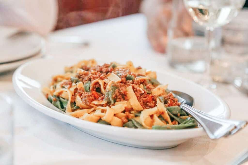 Ragú Bolognese, wheat noodles with a meat sauce on a plate with a spoon